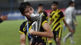 Pesepak bola Tim Nasional Malaysia U-19 Muhammad Faiz Amer Runnizar berselebrasi mencium piala usai mengalahkan Tim Nasional Laos U-19 dalam babak final Piala AFF U-19 2022 di Stadion Patriot Candrabhaga, Bekasi, Jawa Barat, Jumat (15/7/2022). [Antara Foto]

