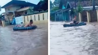 Cuma di +62! Pria Santai Rebahan di Kasur Hanyut Meski Banjir Setinggi Paha, Publik: Kapan Lagi Ya Pak?