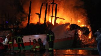 Petugas Dinas Pemadam Kebakaran Kota Surabaya memadamkan kapal kargo yang terbakar di Pelabuhan Kalimas Surabaya, Jawa Timur, Minggu (17/7/2022). [ANTARA FOTO/Didik Suhartono/aww]