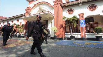 Personel Korps Brimob berjaga di area Gedung Pengadilan Negeri Surabaya Jalan Arjuno, Surabaya, Jawa Timur, Senin (18/7/2022). [ANTARA FOTO/Didik Suhartono/tom]
