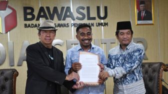 Direktur Kata Rakyat Alwan Ola Riantoby (tengah) bersama Direktur Eksekutif Lingkar Madani Ray Rangkuti (kanan) dan Sekjen Komite Independen Pemantau Pemilu (KIPP) Kaka Suminta (kiri) menunjukkan laporan dugaan pelanggaran kampanye oleh Menteri Perdagangan Zulkifli Hasan di Badan pengawas Pemilihan Umum Republik Indonesia (Bawaslu RI), Jakarta, Selasa (19/7/2022).  ANTARA FOTO/Aditya Pradana Putra