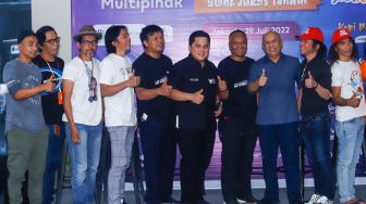 Menteri BUMN Erick Thohir (keenam kiri), Menteri Koperasi dan UKM Teten Masduki (ketiga kanan) bersama grup band Slank dan para Slankers saat launching koperasi Slankops di Jalan Potlot, Jakarta Selatan, Selasa (19/7/2022). [Suara.com/Alfian Winanto]