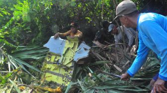 Warga membawa serpihan pesawat tempur latih T-50i Golden Eagle TT-5009 yang jatuh di pegunungan Desa Nginggil, Kradenan, Blora, Jawa Tengah, Selasa (19/7/2022).  ANTARA FOTO/Yusuf Nugroho
