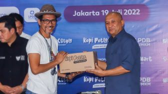 Personil grup band Slank Ridho memberi kopi Potlot kepada Menteri Korupsi dan UKM saat launching koperasi Slankops di Jalan Potlot, Jakarta Selatan, Selasa (19/7/2022). [Suara.com/Alfian Winanto]