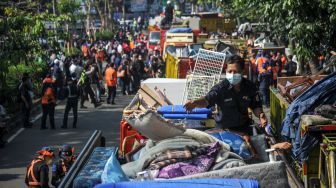 Petugas mengeluarkan barang dari dalam rumah saat penertiban aset milik PT KAI di Jalan Laswi, Bandung, Jawa Barat, Rabu (20/7/2022).  ANTARA FOTO/Raisan Al Farisi
