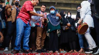 Keluarga korban dan warga sekitar saat menggelar aksi tabur bunga di Jalan Transyogi Cibubur, Bekasi, Jawa Barat, Rabu (20/7/2022). [Suara.com/Alfian Winanto]