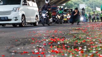 Warga sekitar saat menggelar aksi tabur bunga di Jalan Transyogi Cibubur, Bekasi, Jawa Barat, Rabu (20/7/2022). [Suara.com/Alfian Winanto]