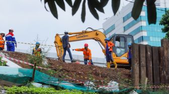 Pekerja beraktivitas di TKP kebocoran gas di proyek revitalisasi Halte Transjakarta Cawang, Jakarta Timur, Rabu (20/7/2022). [Suara.com/Alfian Winanto]