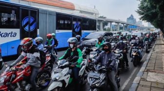 Sejumlah kendaraan bermotor melintas di Jalan MT Haryono, Jakarta Timur, Kamis (21/7/2022). [Suara.com/Alfian Winanto]