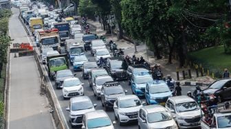 Sejumlah kendaraan bermotor melintas di Jalan MT Haryono, Jakarta Timur, Kamis (21/7/2022). [Suara.com/Alfian Winanto]