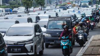 Sejumlah kendaraan bermotor melintas di Jalan MT Haryono, Jakarta Timur, Kamis (21/7/2022). [Suara.com/Alfian Winanto]