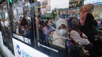 Penumpang menaiki kedatangan bus TransJakarta di Halte Tosari, Jakarta Pusat, Kamis (21/7/2022). [Suara.com/Alfian Winanto]