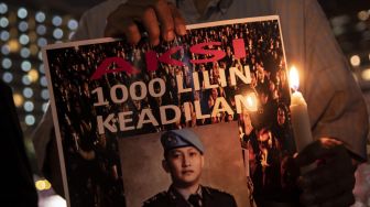 Peserta aksi dari Tim Advokat Penegakan Hukum dan Keadilan (TAMPAK) memegang poster saat aksi seribu lilin dan doa bersama untuk Alm Brigadir Yosua Hutabarat di Bundaran HI, Jakarta, Jumat (22/7/2022).  ANTARA FOTO/Muhammad Adimaja
