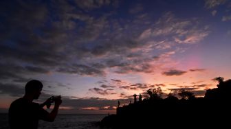 Wisatawan asing memotret suasana matahari terbenam di Pantai Batu Bolong, Senggigi, Lombok Barat, NTB, Sabtu (23/7/2022). [ANTARA FOTO/Ahmad Subaidi/wsj]