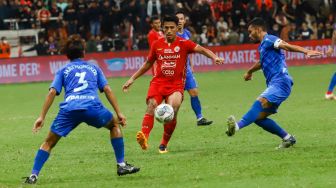 Pesepakbola Persija Jakarta Hanif Syahbandi (tengah) berusaha melewati pemain Chonburi FC saat laga persahabatan dalam rangka Grand Launching Jakarta International Stadium (JIS) di Tanjung Priok, Jakarta Utara, Minggu (24/7/2022). [Suara.com/Alfian Winanto]