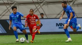 Pesepakbola Persija Jakarta Rico Simanjuntak (tengah) berusaha melewati pemain Chonburi FC saat laga persahabatan dalam rangka Grand Launching Jakarta International Stadium (JIS) di Tanjung Priok, Jakarta Utara, Minggu (24/7/2022). [Suara.com/Alfian Winanto]