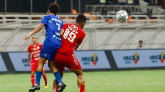 Pesepakbola Persija Jakarta Taufik Hidayat (kanan) berebut bola dengan pesepakbola Chonburi FC  Chatmongkol Rueang Thanarot (kiri) saat laga persahabatan dalam rangka Grand Launching Jakarta International Stadium (JIS) di Tanjung Priok, Jakarta Utara, Minggu (24/7/2022). [Suara.com/Alfian Winanto]