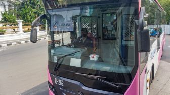 Bus pink Transjakarta saat tiba di Halte Pasar Baru, Jakarta Pusat, Rabu (27/7/2022). [Suara.com/Alfian Winanto]