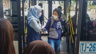 Penumpang turun dari Bus pink Transjakarta di Halte Pasar Baru, Jakarta Pusat, Rabu (27/7/2022). [Suara.com/Alfian Winanto]