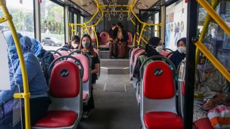 Penumpang menaiki bus pink Transjakarta di Halte Pasar Baru, Jakarta Pusat, Rabu (27/7/2022). [Suara.com/Alfian Winanto]