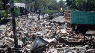 Warga mencari sisa barang yang masih berharga di lokasi pembongkaran bangunan di kawasan simpang Aloha, Sidoarjo, Jawa Timur, Rabu (27/7/2022).  ANTARA FOTO/Umarul Faruq
