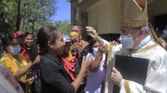 Sejumlah warga berebut mendapatkan berkat tangan dari Duta Besar Vatikan untuk Indonesia Mgr Piero Pioppo di halaman Gereja Santa Maria Assumpta di Kota Kupang, NTT, Rabu (27/7/2022). ANTARA FOTO/Kornelis Kaha