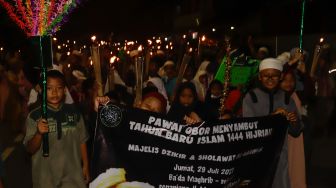 Umat muslim mengikuti pawai obor menyambut Tahun Baru Islam di kawasan Manggarai, Jakarta Selatan, Jumat (29/7/2022). [Suara.com/Alfian Winanto]