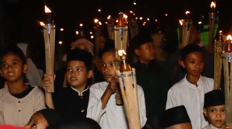 Umat muslim mengikuti pawai obor menyambut Tahun Baru Islam di kawasan Manggarai, Jakarta Selatan, Jumat (29/7/2022). [Suara.com/Alfian Winanto]