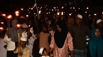 Umat muslim mengikuti pawai obor menyambut Tahun Baru Islam di kawasan Manggarai, Jakarta Selatan, Jumat (29/7/2022). [Suara.com/Alfian Winanto]