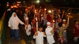 Umat muslim mengikuti pawai obor menyambut Tahun Baru Islam di kawasan Manggarai, Jakarta Selatan, Jumat (29/7/2022). [Suara.com/Alfian Winanto]