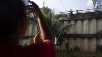 Pedagang mengerek makanan pesanan pembeli di dalam ember di Warung Kerek Ember di Kuningan Barat, Jakarta, Jumat (29/7/2022). ANTARA FOTO/Syahrudin