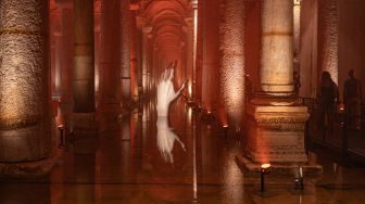 Orang-orang mengunjungi situs bersejarah Basilica Cistern di Istanbul, Turki, Selasa (26/7/2022). [Yasin AKGUL/AFP]