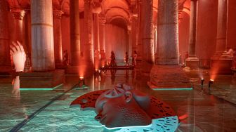 Orang-orang mengunjungi situs bersejarah Basilica Cistern di Istanbul, Turki, Selasa (26/7/2022). [Yasin AKGUL/AFP]