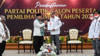 Ketua Komisi Pemilihan Umum (KPU) Hasyim Asy'ari (kanan) berjabat tangan usai menerima berkas pendaftaran dari Presiden Partai Keadilan Sejahtera (PKS) Ahmad Syaikhu (kiri) saat Pendaftaran Partai Politik Calon Peserta Pemilu tahun 2024 di Kantor KPU, Jakarta, Senin (1/8/2022). [ANTARA FOTO/M Risyal Hidayat/nym]
