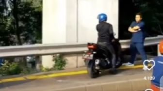 Sambil Lipat Tangan, Pejalan Kaki Halangi Pengendara Motor yang Nekat Naik Trotoar