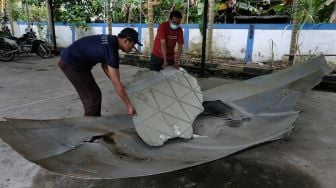 Petugas memperlihatkan lubang di pecahan badan Republik Rakyat Tiongkok (RRT) di Lembaga Penerbangan dan Antariksa Nasional (LAPAN) Pontianak, Kalimantan Barat, Sabtu (6/8/2022). ANTARA FOTO/Jessica Helena Wuysang