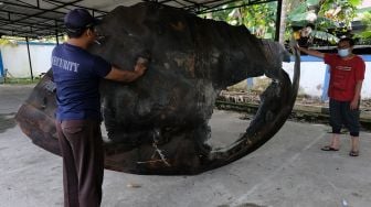 Koordinator Pelaksana Fungsi Layanan Balai Pengamatan Antariksa dan Atmosfer La Ode Muhammad Musafar (kanan) bersama petugas keamanan mengangkat pecahan roket Republik Rakyat Tiongkok (RRT) di Lembaga Penerbangan dan Antariksa Nasional (LAPAN) Pontianak, Kalimantan Barat, Sabtu (6/8/2022). ANTARA FOTO/Jessica Helena Wuysang