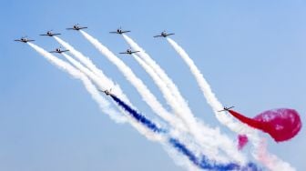 PPesawat K-8E Karakorum dari tim aerobatik Angkatan Udara Mesir 'Silver Stars' bermanuver saat acara Pyramids Air Show 2022 di dataran tinggi Piramida Giza, Mesir, Rabu (3/8/2022). [Mahmoud Khaled / AFP]
