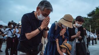 Pengunjung berdoa di depan tugu peringatan di Taman Peringatan Perdamaian Hiroshima di Hiroshima, Jepang, Sabtu (6/8/2022). [Philip FONG / AFP]