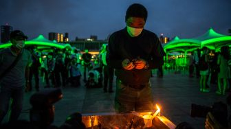 Pengunjung berdoa di depan tugu peringatan di Taman Peringatan Perdamaian Hiroshima di Hiroshima, Jepang, Sabtu (6/8/2022). [Philip FONG / AFP]