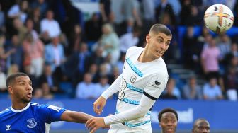 Bek Everton Mason Holgate (kiri) berebut bola dengan gelandang Chelsea Kai Havertz (tengah) saat pertandingan sepak bola Liga Premier Inggris antara Everton dan Chelsea di Stadion Goodison Park, Liverpool, Inggris, Sabtu (6/8/2022). [Lindsey Parnaby / AFP]
