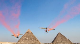 Pesawat bermanuver saat acara Pyramids Air Show 2022 di dataran tinggi Piramida Giza, Mesir, Rabu (3/8/2022). [Mahmoud Khaled / AFP]
