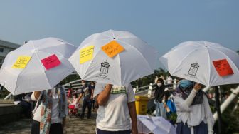 Sejumlah peserta membawa payung yang berisi pesan pentingnya menyusui di Alun-Alun Kota Depok, Depok, Jawa Barat, Minggu (7/8/2022). [ANTARA FOTO/Asprilla Dwi Adha/nym]