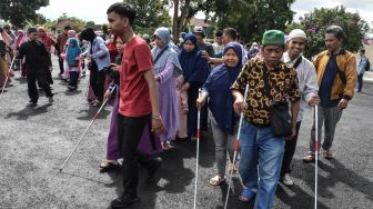 Penyandang tunanetra mengikuti long march rally tongkat dalam rangkaian menyambut HUT ke-77 Kemerdekaan di Saptamarga, Kota Tasikmalaya, Jawa Barat, Minggu (7/8/2022). [ANTARA FOTO/Adeng Bustomi/foc]