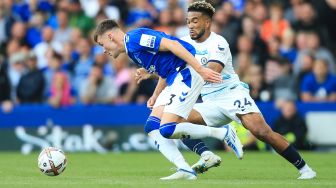 Bek Everton Nathan Patterson (kiri) berebut bola dengan bek Chelsea Reece James saat pertandingan sepak bola Liga Premier Inggris antara Everton dan Chelsea di Stadion Goodison Park, Liverpool, Inggris, Sabtu (6/8/2022). [Lindsey Parnaby / AFP]
