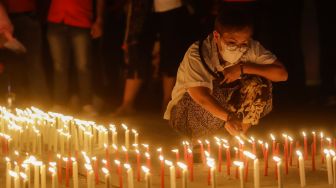 Peserta menyalakan lilin saat aksi tiga ribu lilin dan doa bersama untuk Alm Brigadir Nofriansyah Yosua Hutabarat di Taman Ismail Marzuki, Jakarta Pusat, Senin (8/8/2022). [Suara.com/Alfian Winanto]