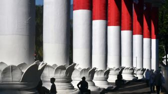 Sejumlah warga duduk di Lawang Salapan yang dibalut bendera Merah Putih di Kota Bogor, Jawa Barat, Senin (8/8/2022). ANTARA FOTO/Arif Firmansyah