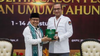Ketua Komisi Pemilihan Umum (KPU) Hasyim Asy'ari (kanan) menerima cinderamata dari Ketua Umum Partai Kebangkitan Bangsa (PKB) Muhaimin Iskandar (kiri) saat Pendaftaran Partai Politik Calon Peserta Pemilu tahun 2024 di Kantor KPU, Jakarta Pusat, Senin (8/8/2022). [Suara.com/Alfian Winanto]