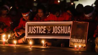 Aliansi Pemuda Batak Bersatu (PBB) memegang poster saat aksi tiga ribu lilin dan doa bersama untuk Alm Brigadir Nofriansyah Yosua Hutabarat di Taman Ismail Marzuki, Jakarta Pusat, Senin (8/8/2022). [Suara.com/Alfian Winanto]