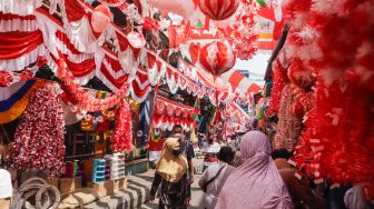 Warga memilih pernak-pernik untuk perayaan Hari Kemerdekaan ke-77 Republik Indonesia di Pasar Jatinegara, Jakarta Timur, Selasa (9/8/2022). [Suara.com/Alfian Winanto]
